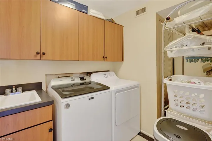Spacious laundry with storage cabinets, wash sink and extra storgae space