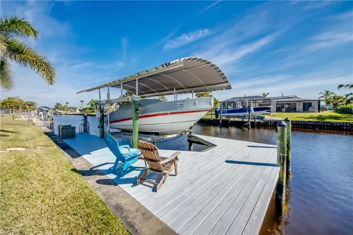 View of dock featuring a water view and a lawn