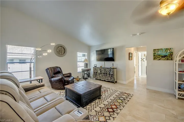 Living room with lofted ceiling and ceiling fan