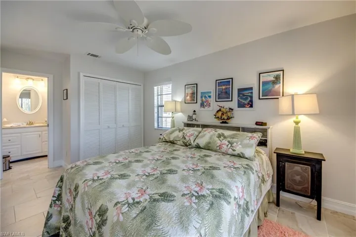 Bedroom with sink, connected bathroom, ceiling fan, and a closet