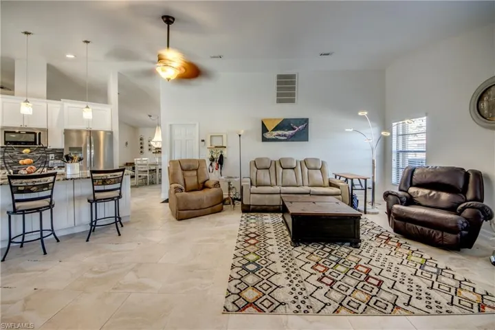 Living room featuring ceiling fan and a towering ceiling