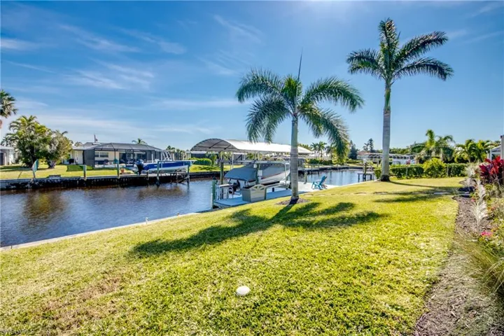 Dock area with a yard and a water view