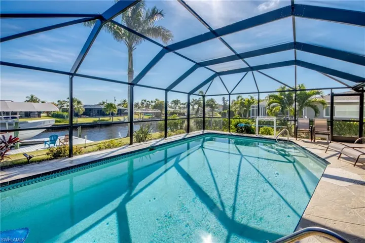 View of pool with a lanai, a patio area, and a water view
