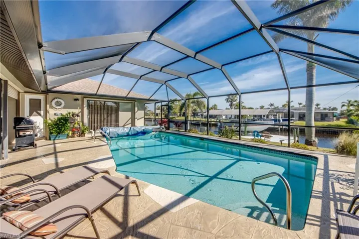 View of swimming pool featuring a water view, a patio, a lanai, and area for grilling