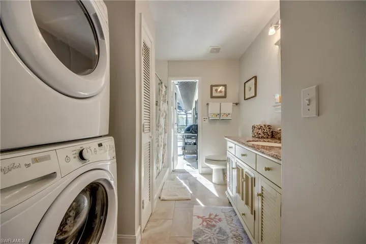 Laundry room featuring stacked washer / dryer and sink