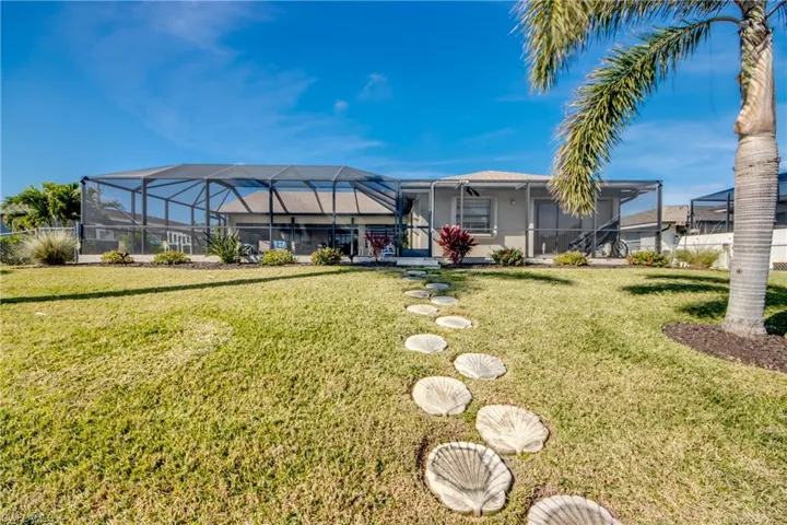 Rear view of property featuring a lanai and a yard