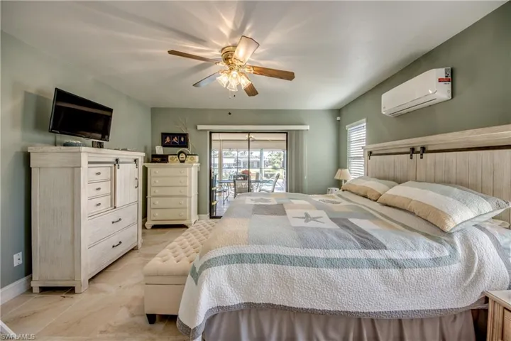 Bedroom with an AC wall unit, access to exterior, and ceiling fan
