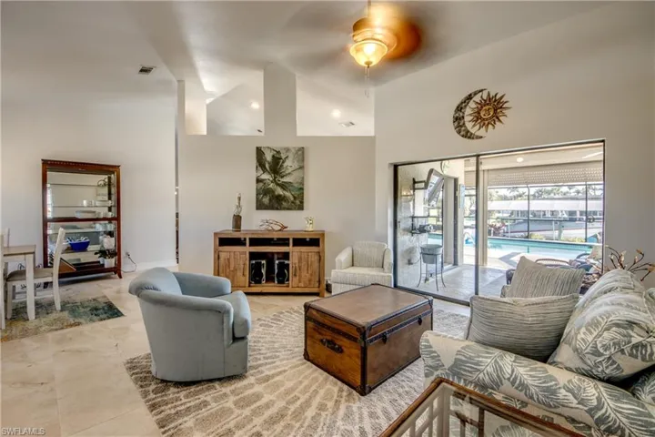 Living room featuring ceiling fan and high vaulted ceiling