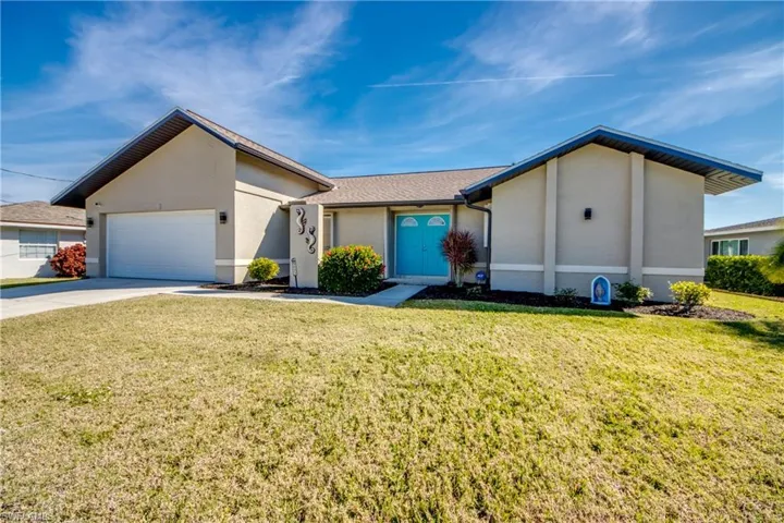 Ranch-style home with a garage and a front lawn