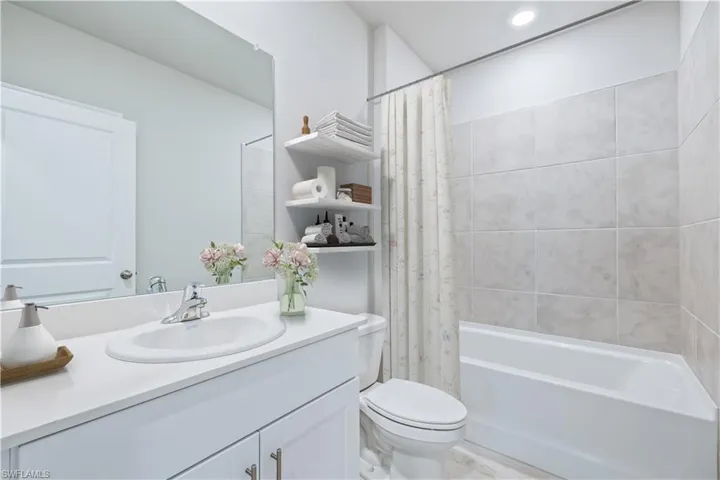 Full bathroom featuring vanity, shower / tub combo, and toilet