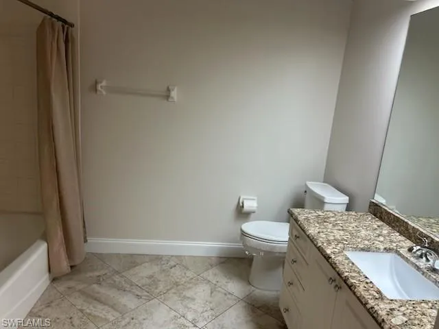 Bathroom featuring shower / bathtub combination with curtain and vanity