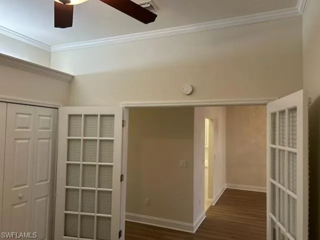 Hall featuring ornamental molding and dark wood-style flooring