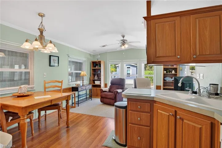 Kitchen featuring brown cabinets, vaulted ceiling, light countertops, light wood finished floors, and open floor plan