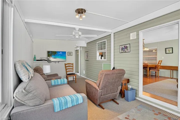 Sunroom featuring beam ceiling, ceiling fan, and outdoor lounge area