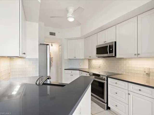 sleed and compact kitchen with nice tile backsplash and neutral tile