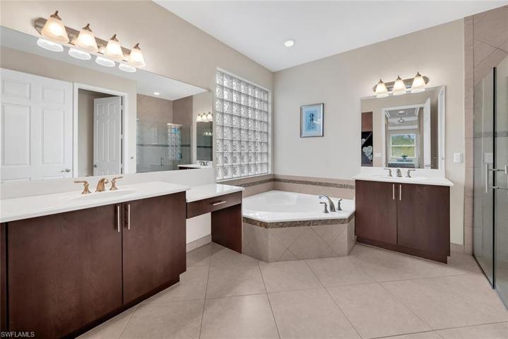 Spacious Master Bathroom featuring: upgraded cabinets, soaking tub and a frameless shower door.