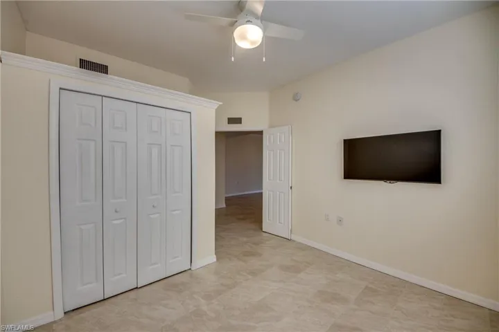 Guest Bedroom 1 with mounted TV and large closet