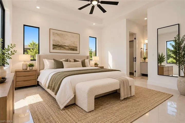 Tray ceiling with integrated ceiling fan, tall windows, and polished tile flooring