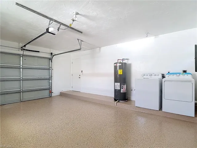 Garage with a garage door opener, independent washer and dryer, and electric water heater
