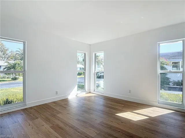 Unfurnished room featuring hardwood / wood-style flooring and plenty of natural light
