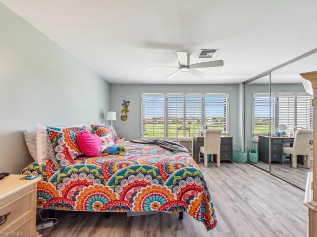 Bedroom featuring ceiling fan, a closet, light hardwood / wood-style flooring, and multiple windows