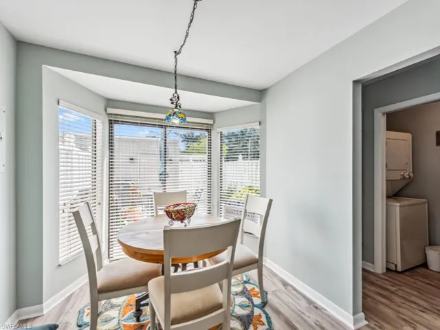Dining area featuring stacked washer / dryer, hardwood / wood-style flooring, and a healthy amount of sunlight