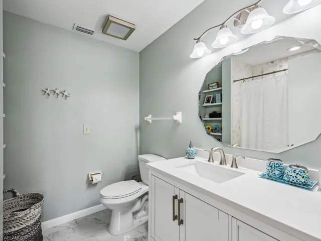 Bathroom featuring toilet, tile patterned floors, and vanity