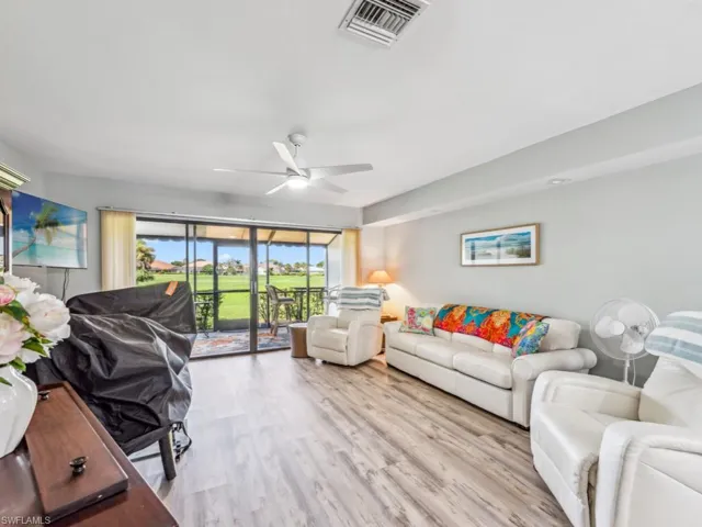 Living room with light wood-type flooring and ceiling fan