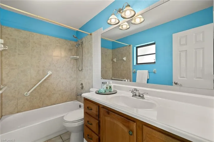 Full bath with shower / washtub combination, toilet, vanity, and tile patterned floors