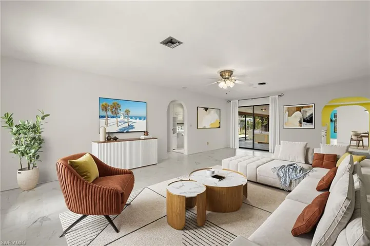 Virtually staged, Living room featuring arched walkways, visible vents, marble finish floor, and ceiling fan