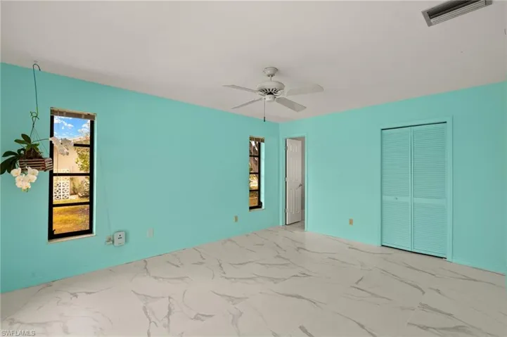 Unfurnished room featuring a ceiling fan, visible vents, and marble finish floor