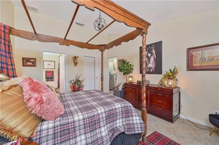 Bedroom featuring a vaulted ceiling and a decorative wrought iron chandelier
