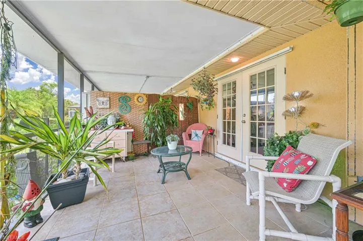 Screened patio featuring a tiled floor and an exterior wall with a textured finish