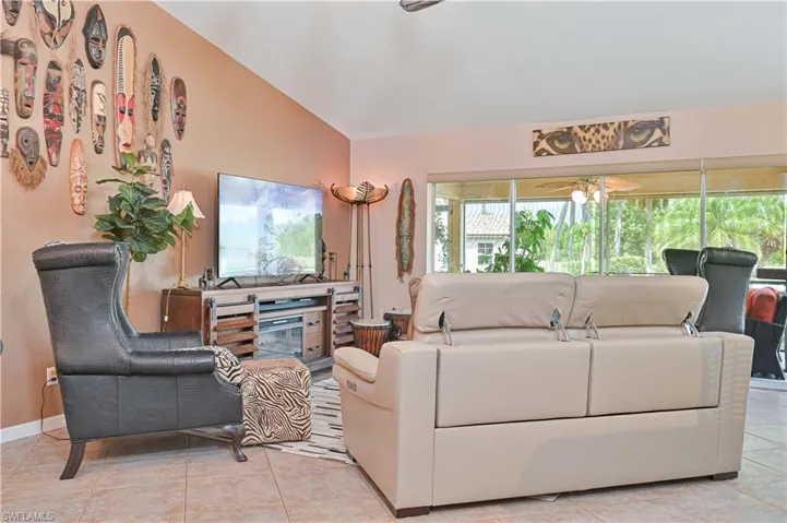 Living area featuring tile flooring, a media console with storage, and a large sliding glass door