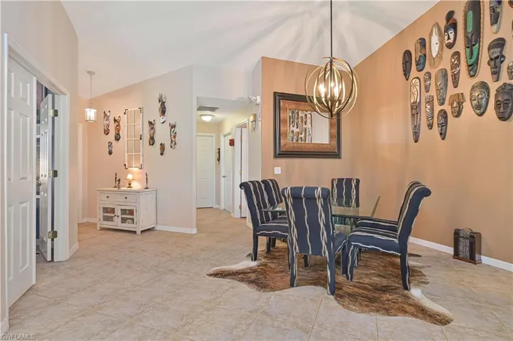 Dining area featuring a contemporary spherical chandelier and neutral tile flooring