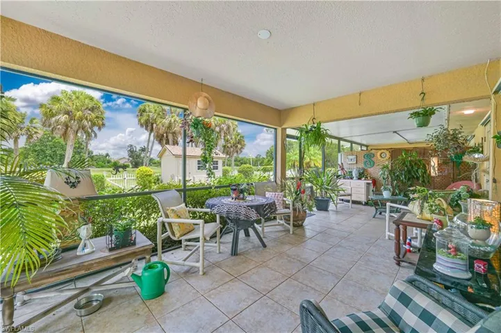 Screened lanai featuring tiled flooring, a textured ceiling, a built-in storage cabinet, and panoramic outdoor scenery