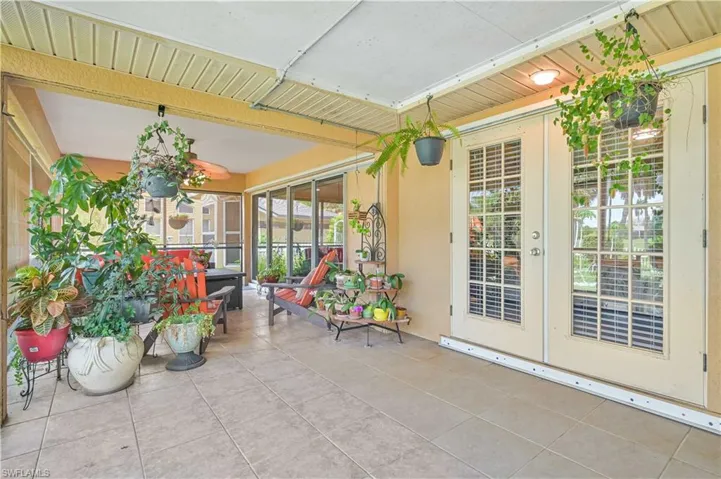 Covered outdoor patio featuring light-colored square tile flooring and a cream-colored exterior wall
