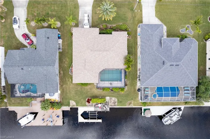 Waterfront property featuring a screened-in swimming pool with an attached spa