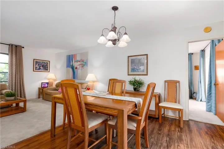 Dining area featuring wood-finish flooring, a decorative chandelier, and an open layout