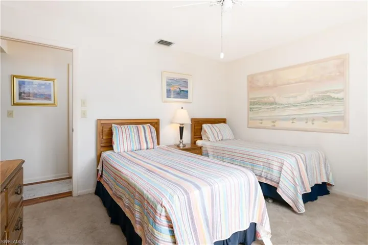 Carpeted bedroom with two wood-finish twin beds