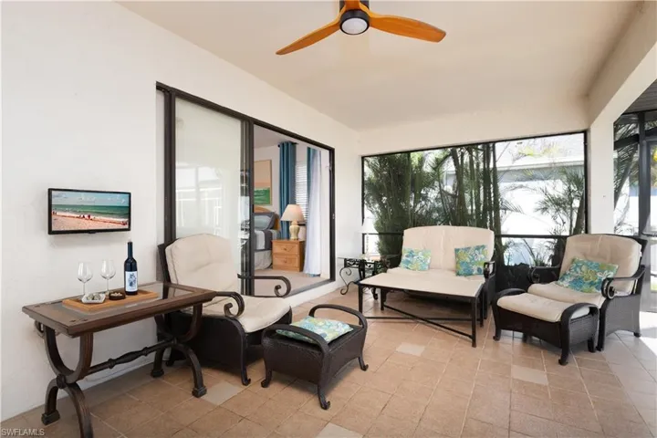 Screened patio featuring tile flooring and a ceiling fan