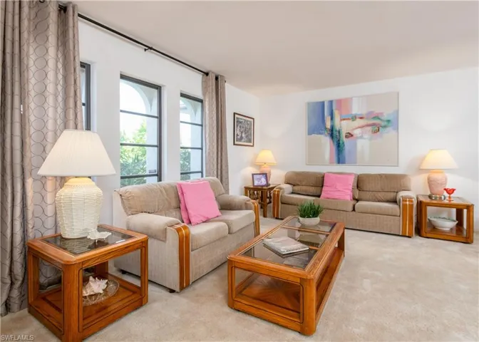 Carpeted living space with multiple arched windows