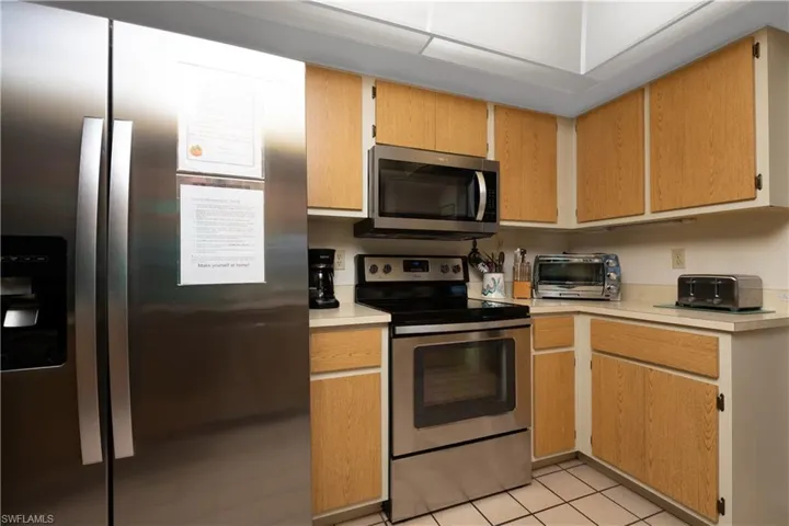 Kitchen featuring stainless steel appliances, light wood-finish cabinetry, and neutral countertops
