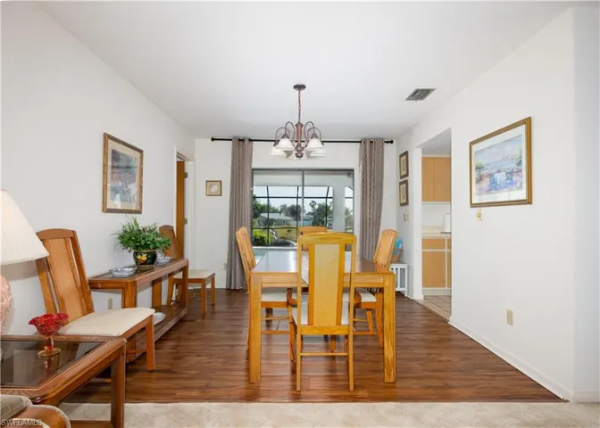 Dining area featuring wood-finish flooring, a chandelier, and sliding glass doors leading to an outdoor space
