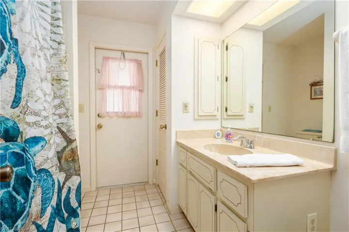 Bathroom vanity featuring a single basin sink and a light-toned countertop
