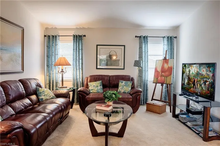 Carpeted living area featuring light-toned walls