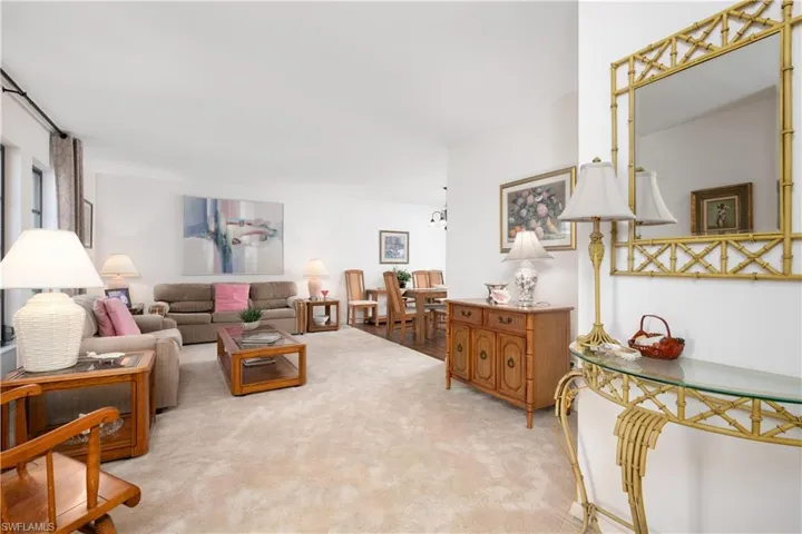 Expansive carpeted living area with white walls and natural light