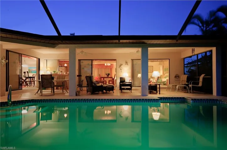 Screened lanai featuring a swimming pool with tile coping and a tiled patio