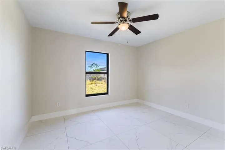 Unfurnished room with light marble finish floors and a ceiling fan