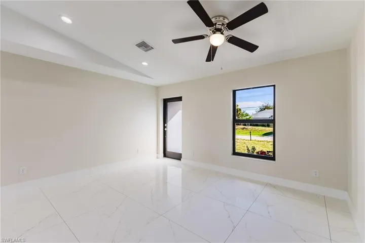 Spare room featuring vaulted ceiling, recessed lighting, light marble finish floors, and ceiling fan